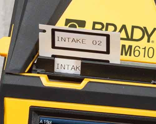 Świeżo wydrukowane etykiety wychodzące z drukarki M610. 