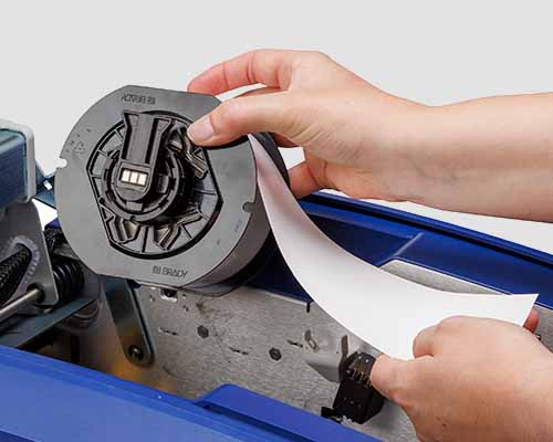 Osoba wymieniająca podłoże do etykiet w drukarce S3700.